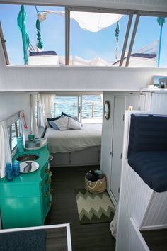 the inside of a small boat with a bed and dresser