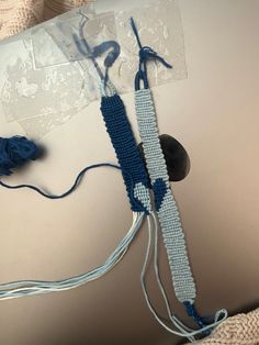 a crocheted blue and white object on top of a laptop computer with wires attached to it