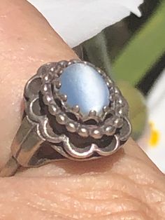 Vintage antique sterling silver light blue cats like glass cabochon ? This ring is really nice, it is an unusual make, it is adjustable by one side sliding into the top of the rain and back out so it adjusts from approximately 7 to size 8 please see photos as the band is slightly out of shape but it does not affect the feel of the ring at all. I am not sure if this is glass cat's-eye or a light blue gemstone it is slightly mottled at the top which you cannot see unless you look up very close. Th Vintage Oval Moonstone Ring Hallmarked, Vintage Blue Cabochon Ring, Handmade Vintage Sterling Silver Moonstone Ring, Vintage Oval Cabochon Opal Ring, Vintage Silver Handmade Moonstone Ring, Vintage Cabochon Moonstone Ring For Anniversary, Vintage Style Blue Opal Ring Gift, Vintage Round Cabochon Moonstone Ring, Vintage Oval Cabochon Opal Ring Collectible