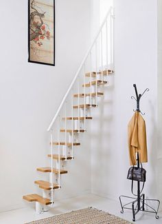 there is a coat rack on the wall next to some stairs with an umbrella hanging from it