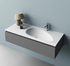 a bathroom sink sitting on top of a white counter next to a wall mounted faucet