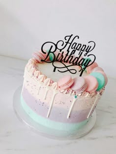 a birthday cake decorated with colorful icing and sprinkles on a white table