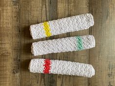 three crocheted toothbrush holders sitting on top of a wooden table