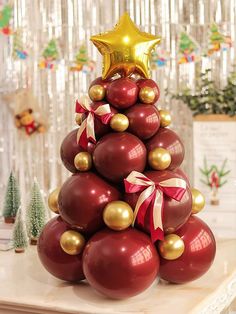 a christmas tree made out of red balls and gold ornaments with a star on top