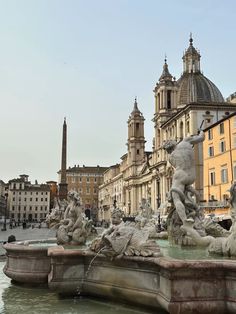 the fountain is surrounded by statues and buildings