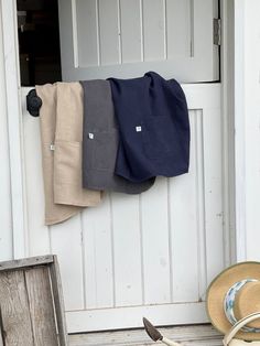 an open door with hats hanging on it and a hat laying next to the door