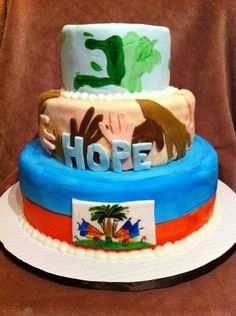 three tiered cake decorated with flags and the word hope on each layer, sitting on top of a white plate