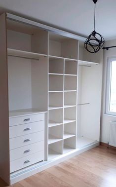 an empty room with white shelves and drawers