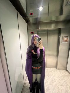 a woman taking a selfie in an elevator with purple hair and black stockings on