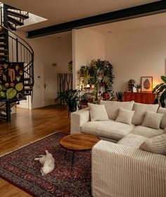 a living room filled with furniture and a spiral stair case in the center of the room