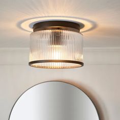 a light fixture hanging from the ceiling above a mirror