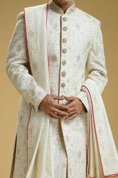 Off-white silk dupion sherwani with floral jaali embroidery. Comes with a cotton silk kurta, churidar, and a stole.
Component: 4
Pattern: Embroidered
Type Of Work: Floral jaali
Neckline: Mandarin collar
Sleeve Type: Full
Fabric: Silk dupion, Kurta : Cotton silk
Color: Off White
Other Details: 
Embellished buttons on front placket
Embroidered borders on stole
Occasion: Groom, Wedding - Aza Fashions Stole For Men, Embroidered Sherwani, Embellished Buttons, Kurta Cotton, Silk Kurta, March 2024, Fabric Silk, Churidar, White Silk