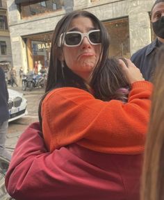 a woman is hugging another woman on the street