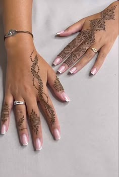 two hands with henna tattoos on them