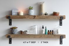 two wooden shelves with bottles and candles on top of them next to each other in front of a white wall