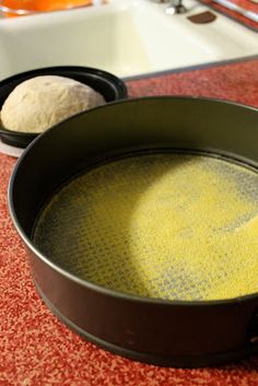 a pan with some food inside of it on a counter top next to a sink