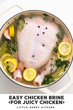 a chicken in a pot with lemons and herbs