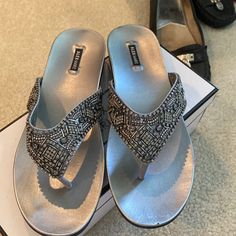 Brand New, Never Worn Sandals. Color Is Silver/Grey With Beading. Box Included May Not Match Style Tag, But Matches Brand Silver Toe Post Sandals With Rhinestones, Silver Embellished Toe Post Sandals, Silver Embellished Flat Sandals, Silver Rhinestone Toe Post Sandals, Gray Non-slip Flip Flops For Beach, Elegant Silver Sandals With 4-inch Heel, Gray Synthetic Slip-on Sandals, Silver Fitted Sandals With 4-inch Heel, Silver Sandals With 4-inch Heel