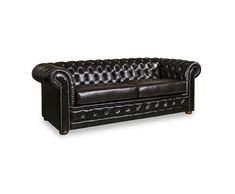 a black leather couch sitting on top of a white floor