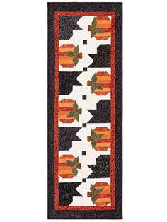 an orange and black quilt with leaves on it