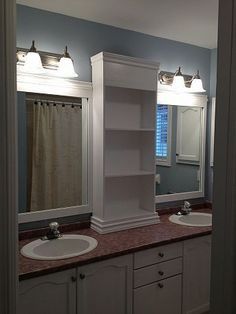 a bathroom with two sinks and a bookcase in the middle of the countertop