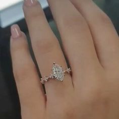 a woman's hand with a diamond ring on top of her finger and an engagement band