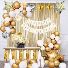 a birthday party with gold and white balloons