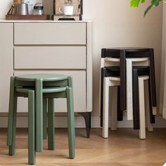 three stools in front of a white dresser and coffee pot on top of it