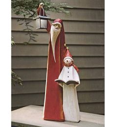 a statue of santa claus and a person holding a lantern