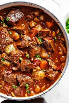 a pot filled with stew and vegetables on top of a table