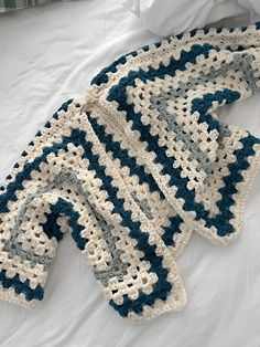 a crocheted blanket laying on top of a bed