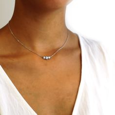 Our Marigold three-stone diamonds are set in beaded pods. It is suspended from the cable chain. About this necklace: Made in solid 14k white gold (rhodium plated) choose from different weights, 1.1ctw Total 1.1ctw three diamonds (shown) 0.6ct round center, (2) 0.25ct sides Color G-H, clarity SI1 Your choice of a 16-inch diamond-cut 1.4mm cable chain with lobster Please allow 3-4 weeks for shipping. If you need it sooner, we can sometimes expedite. Thinking of using a different stone? We can cust Luxury Minimalist Three Stone Jewelry, Luxury White Gold Three Stone Necklace, Luxury Three Stone Minimalist Jewelry, Luxury Gold Three Stone Necklace, Luxury Three-stone Necklaces For Women, 3 Stone Diamond Necklace, Three Diamond Necklace, 3 Diamond Necklace, Necklace Ideas