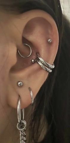 a close up of a person's ear with two different piercings on it