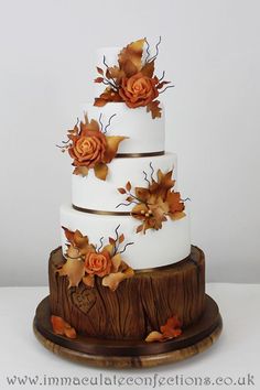 a three tiered cake decorated with flowers and leaves