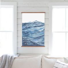 a living room with white walls and blue ocean waves on the wall, framed in wood