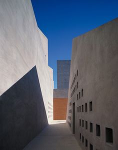 an alley way between two buildings with windows on each side and one in the middle