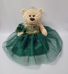 a teddy bear dressed in a green dress