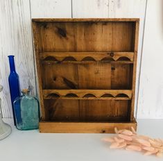 a wooden shelf with bottles and vases next to it