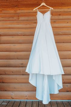 a white dress hanging on a wooden wall