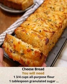 a person is holding up a cheesy bread