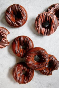 chocolate covered donuts sitting on top of a white counter