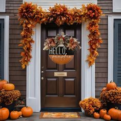 the front door is decorated with fall leaves and pumpkins