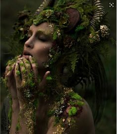 a woman is covered in moss and plants