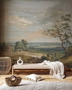 a room with a painting on the wall and a bench in front of it next to a wicker basket