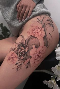 a woman's thigh with flowers and fish on it