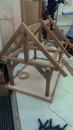 a wooden house being built on top of a workbench