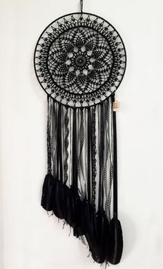 a black and white dream catcher hanging on the wall