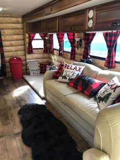 a living room filled with furniture and lots of wood paneled walling next to a window