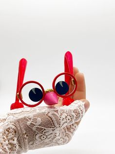 a pair of red eyeglasses held up to the camera