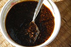 a bowl filled with sauce and meat on top of a table